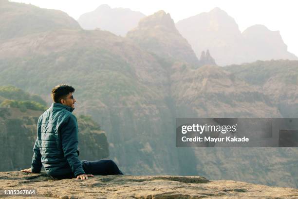 teenager boy sitting at a valley edge - india landscape stock pictures, royalty-free photos & images