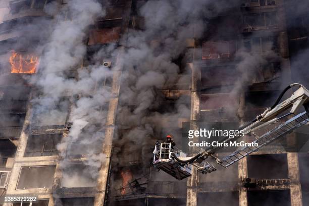Firefighters work to extinguish a fire at a residential apartment building after it was hit by a Russian attack in the early hours of the morning in...