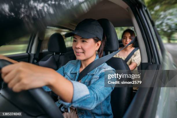 an asian woman driving car for rideshare - car pooling stock pictures, royalty-free photos & images