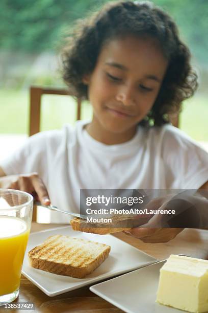 girl buttering toast - untar de mantequilla fotografías e imágenes de stock