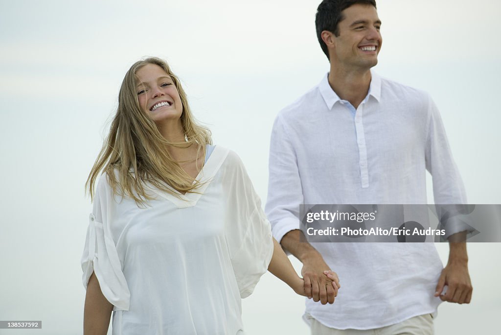 Couple walking hand in hand outdoors