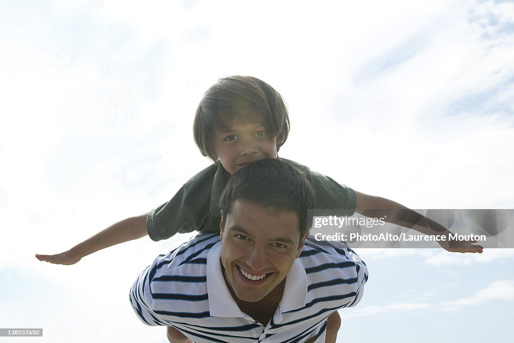 Father carrying son on back, portrait