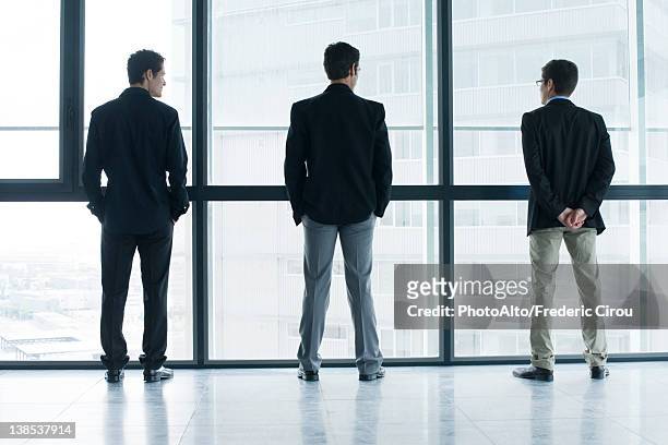 executives standing side by side, looking out window - three people silhouette stock pictures, royalty-free photos & images