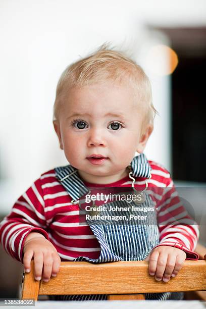 baby boy leaning on chair - baby standing stock pictures, royalty-free photos & images