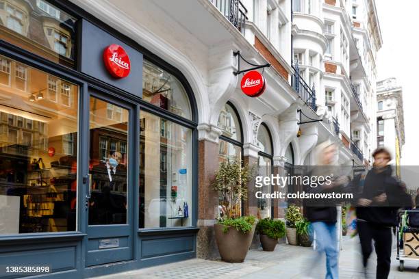 blurred motion of people walking past leica camera store in central london - uk high street shops stock pictures, royalty-free photos & images