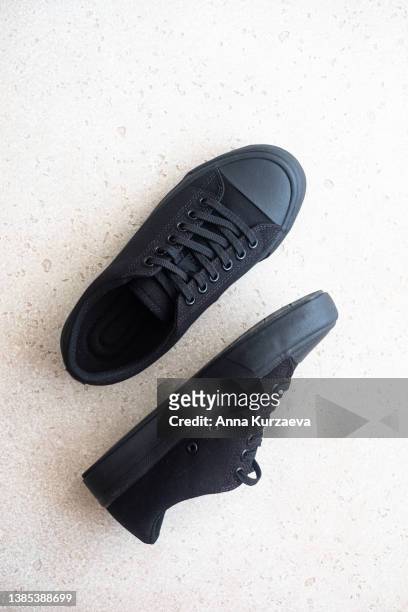 unisex black sneakers on light concrete background, top view - pair stock photos et images de collection