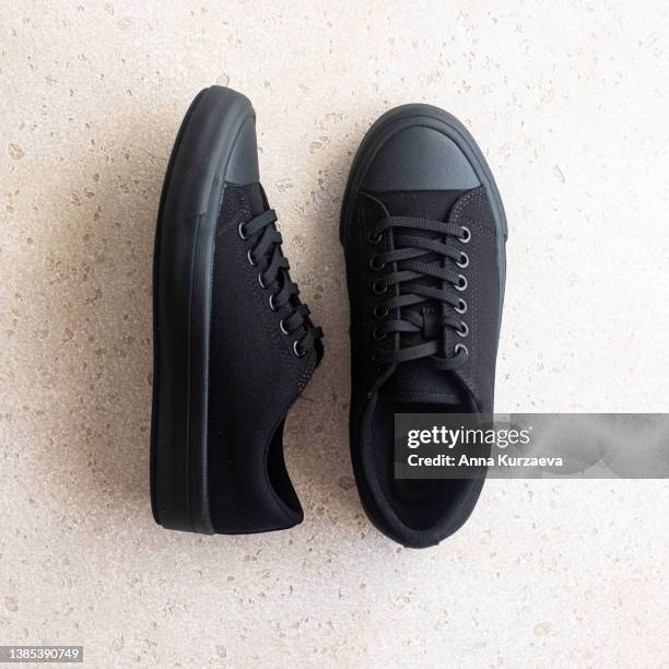 unisex black sneakers on light concrete background, top view - pairs stock pictures, royalty-free photos & images