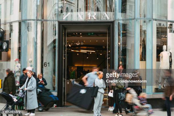 exterior of zara clothing store with blurred motion of people on city street - daily life at oxford street london stock pictures, royalty-free photos & images