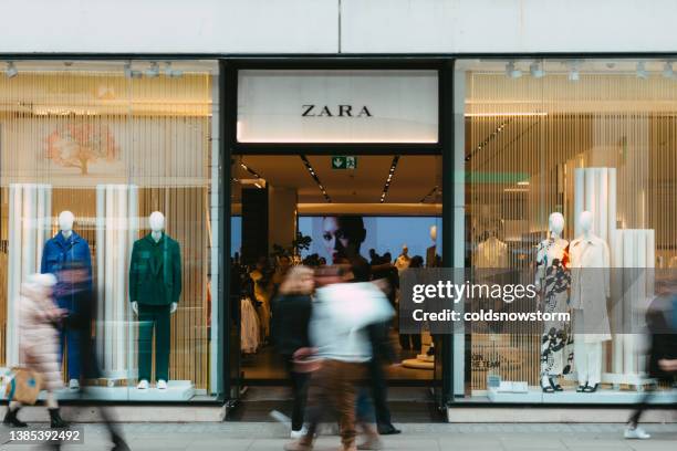 exterior of zara clothing store with blurred motion of people on city street - zara brand name imagens e fotografias de stock