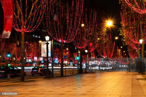 paris : champs-elysees avenue zu weihnachten, mit rotlichtgirlanden in bäumen. - avenue des champs élysées stock-fotos und bilder