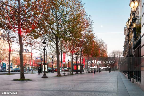 paris : avenue des champs-elysées pour noël, avec des guirlandes de lumière rouge dans les arbres. - quartier des champs élysées photos et images de collection