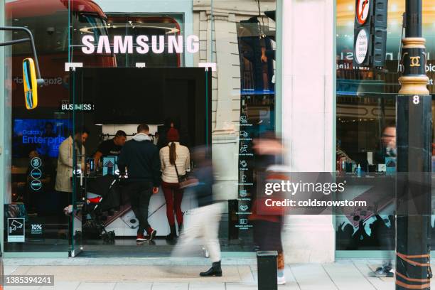 außenansicht des samsung-ladens mit verschwommener bewegung von menschen auf der stadtstraße - samsung stock-fotos und bilder