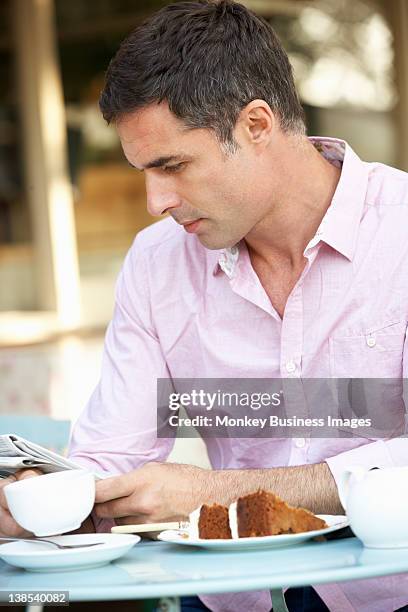 man reading paper outside cafa - monkey eating paper stock pictures, royalty-free photos & images