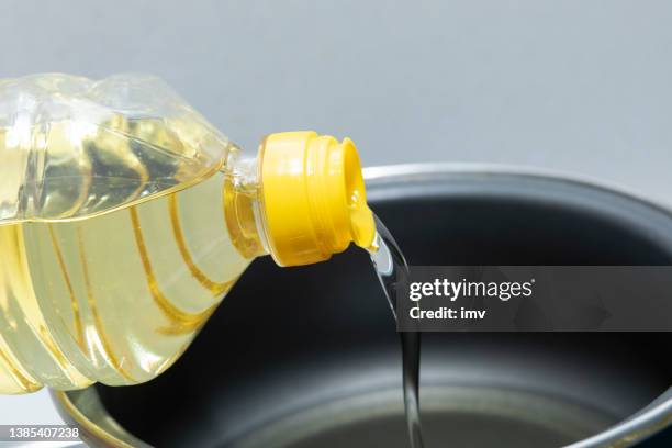 sunflower oil, being poured into a cooking pot - etherische olie stockfoto's en -beelden