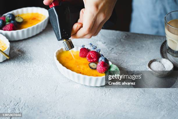 chef cramelizing creme brulee - maçarico - fotografias e filmes do acervo