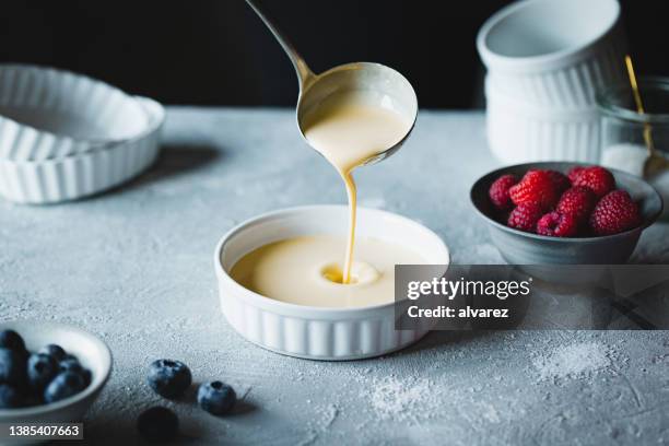 chef preparing creme brulee in kitchen - dessert stockfoto's en -beelden