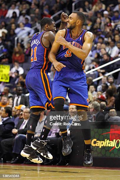 Iman Shumpert of the New York Knicks and Jared Jeffries celebrate during a timeout against the Washington Wizards during the second half at Verizon...