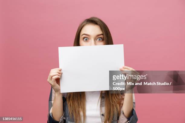 young caucasian woman holding blank paper sheet over isolated - frau mit plakat stock-fotos und bilder