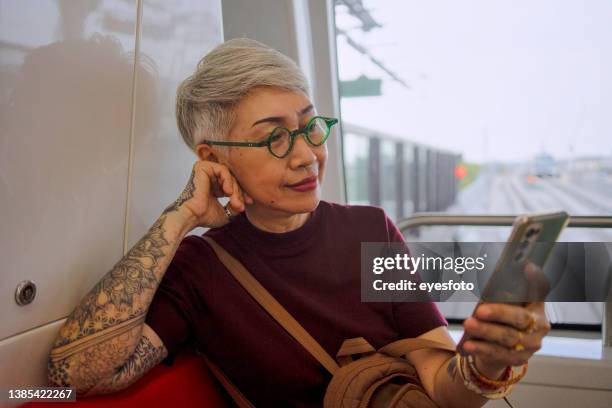senior woman travels by train. - old woman tattoos stock pictures, royalty-free photos & images