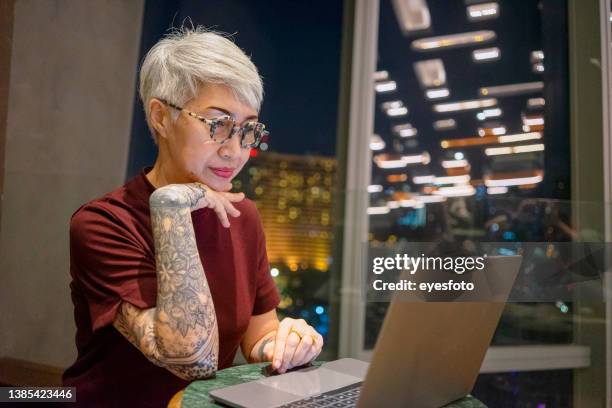 senior woman with technology. daily life at night. - woman searching stock pictures, royalty-free photos & images