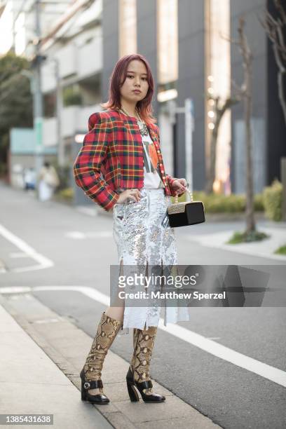 Guest is see wearing red plaid jacket, silver sequin skirt, knee-high socks and black heels with pearl accent bag outside PEIEN during Rakuten...