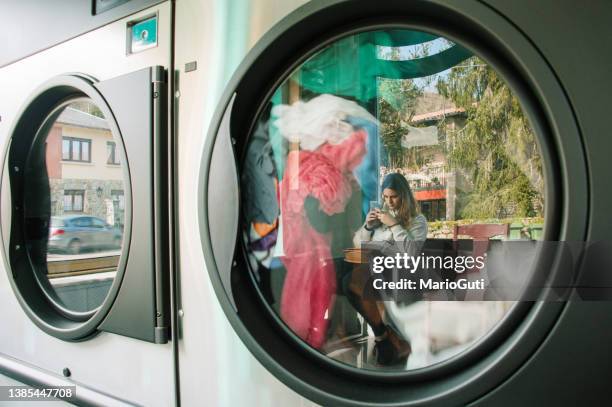 reflexion über eine frau im waschsalon - dryer stock-fotos und bilder