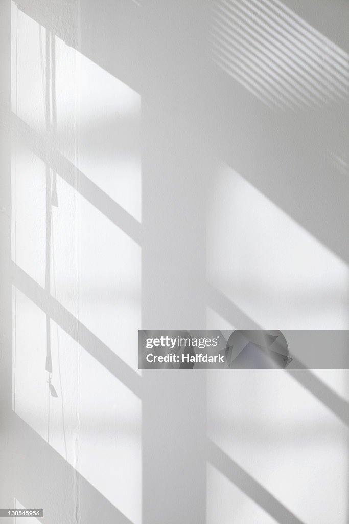 Window glass, blinds and pulley shadows on wall