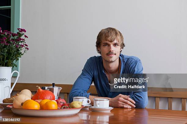 a young man having breakfast, looking at camera - sitting at table looking at camera stock pictures, royalty-free photos & images