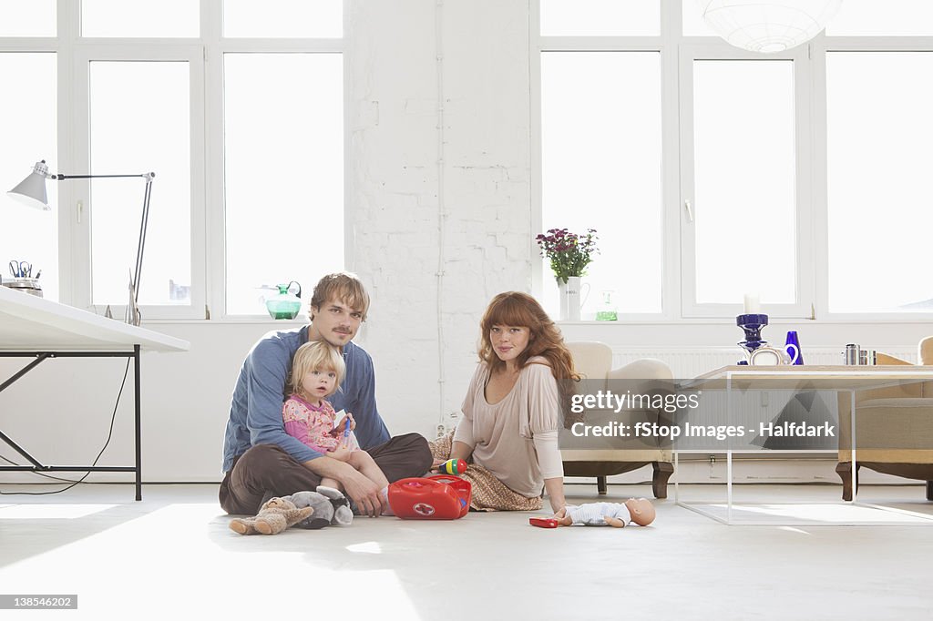 A young family playing with toys on the living room floor