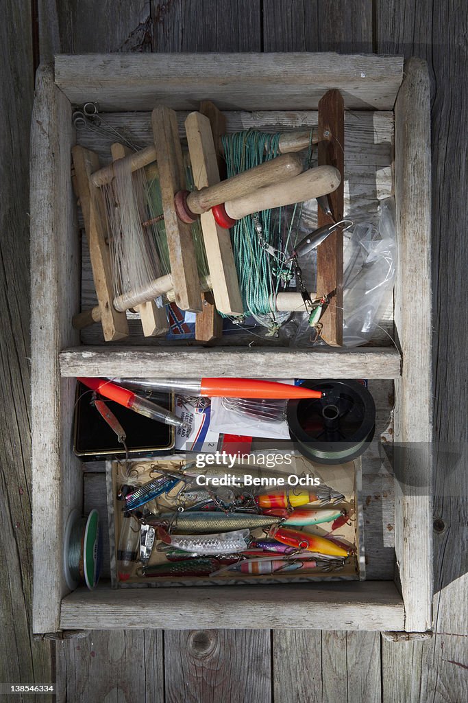 Box of fishing equipment on a background of wood panels