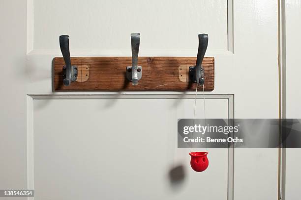 red clown's nose hanging from coat hook on door - clown's nose stock pictures, royalty-free photos & images