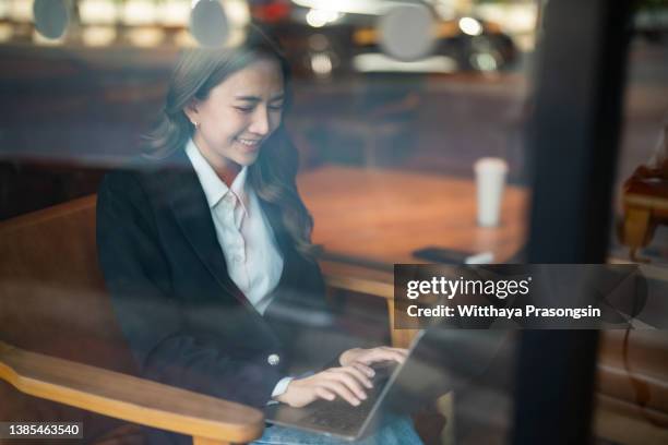 asian woman working laptop at cafe - businesswear stock pictures, royalty-free photos & images