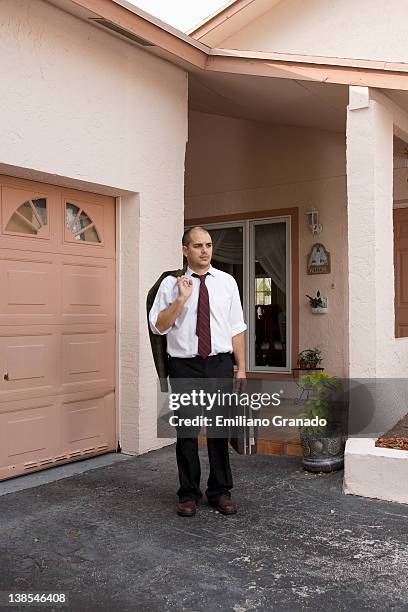 a businessman standing in his driveway looking away - mühsal stock-fotos und bilder