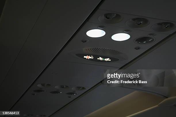illuminated signs on roof of a plane, fasten seat belt sign and no smoking sign - no smoking sign stock-fotos und bilder