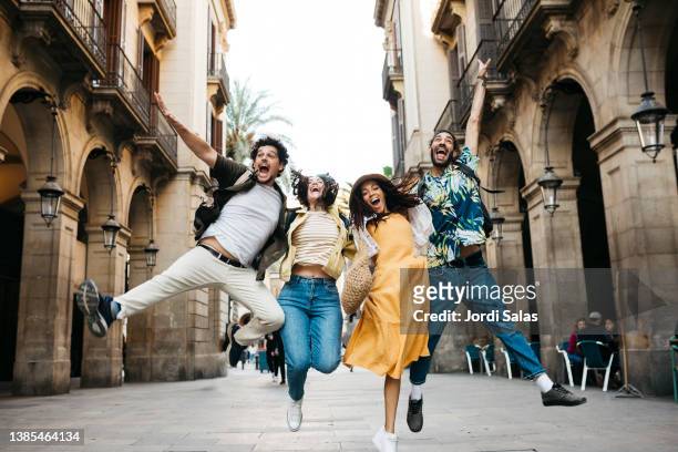 tourists jumping on the street in barcelona - barcelona street stock-fotos und bilder