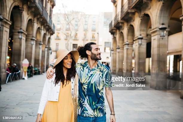 young couple walking around barcelona - couple travelling stockfoto's en -beelden