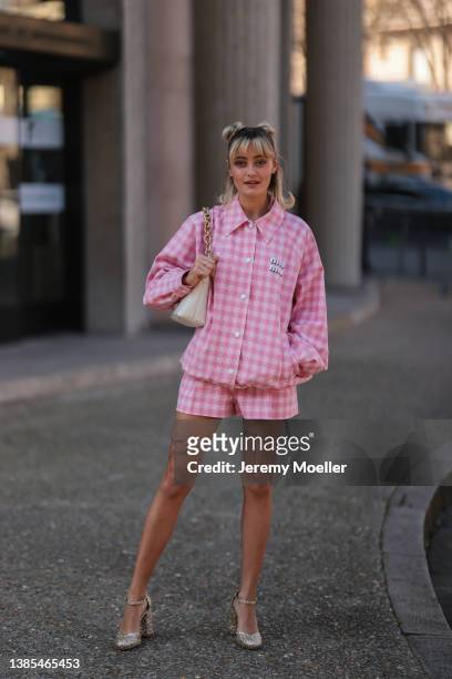 Ella Purnell seen wearing a pink and white oversized checkered jacket from Miu Miu, a matching pink and white checkered shorts, a white handbag and...