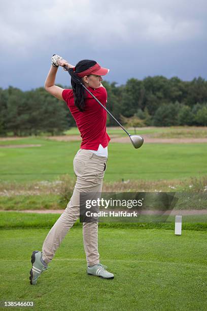 a female golfer teeing off - woman on swing foto e immagini stock