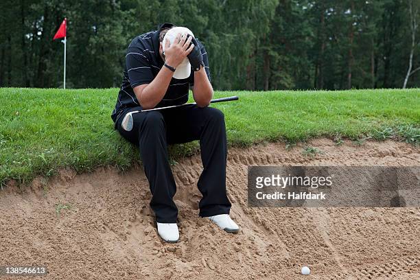 a golfer sitting at the edge of sand trap, head in hands - golf bunker stock pictures, royalty-free photos & images