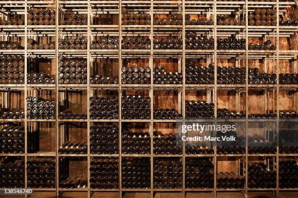 many shelves of bottles of wine - ワインセラー ストックフォトと画像