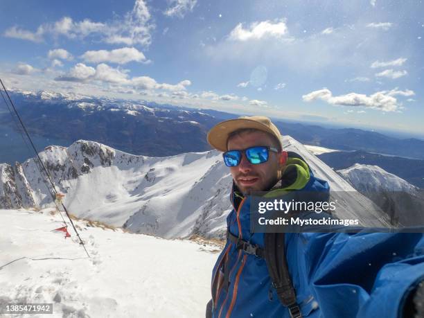 bergsteiger macht im winter erfolgs-selfie auf dem gipfel des berges - schneeschuhwandern stock-fotos und bilder