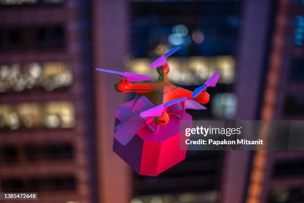 sending gifts with drones across tall buildings is very popular these days. - drone parcel stock pictures, royalty-free photos & images