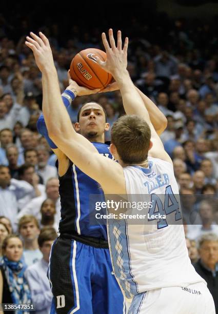 Austin Rivers of the Duke Blue Devils shoots the game-winning 3 pointer over Tyler Zeller to defeat the North Carolina Tar Heels 85-84 during their...