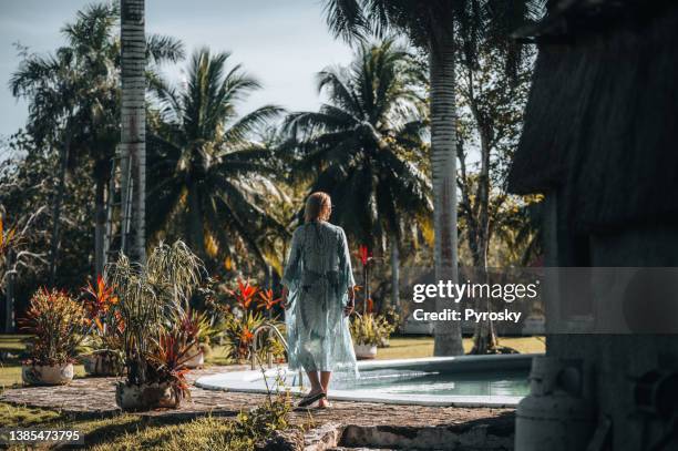 rear view of a woman walking by the pool - flower close up stock pictures, royalty-free photos & images