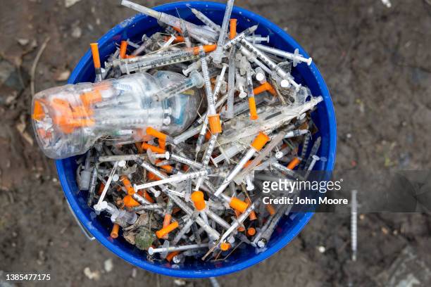 Heroin syringes fill a bucket after volunteers collected them at a homeless encampment on March 13, 2022 in Seattle, Washington. The accumulation of...