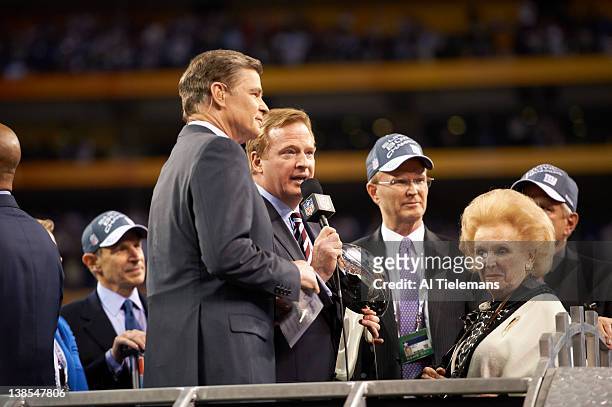 Super Bowl XLVI: NBC Sports media announcer Dan Patrick, NFL commissioner Roger Goodell with Vince Lombardi Trophy, New York Giants CEO and president...