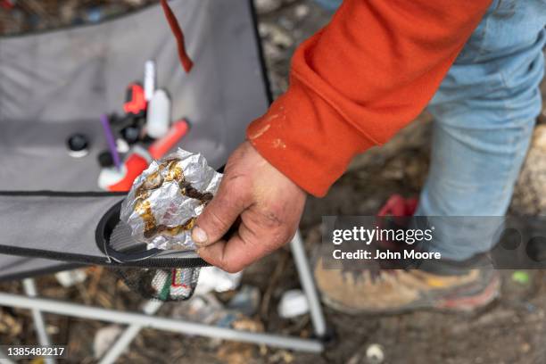 Homeless man holds a piece of aluminum foil he used to smoke fentanyl on March 13, 2022 in Seattle, Washington. Widespread drug addiction is endemic...