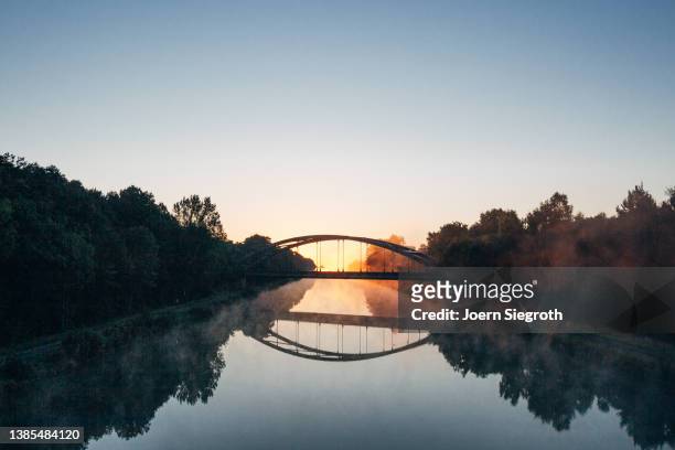 sunrise at a bridge - connected city stock-fotos und bilder