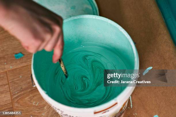 woman's hand stirs paint with a paintbrush - school reform stock pictures, royalty-free photos & images