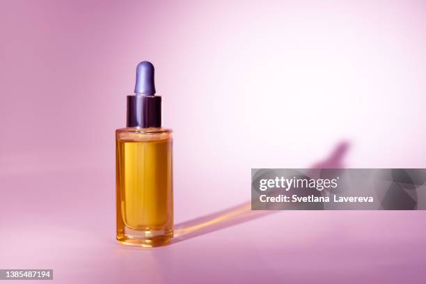 serum glass bottle with pipette on the pink background. natural organic spa cosmetic concept. front view. - flacon compte gouttes photos et images de collection